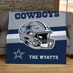 the cowboys throw blanket is sitting on a couch in front of a brick wall and window