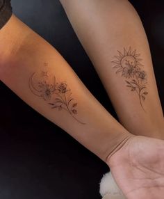 two people with matching tattoos on their arms, one is holding the other's hand