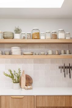 a kitchen with wooden cabinets and shelves filled with dishes