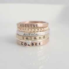 -the Laurel- Stackable Name Ring Set THIS STACKABLE NAME RING SET INCLUDES ALL OF THE RINGS IN THE FIRST PHOTO - a 2 mm rose gold filled name ring in uppercase thin block font - a 2 mm yellow gold filled beaded ring - a 2 mm fine silver name ring in lowercase cursive font - a 2 mm yellow gold filled name ring in lowercase typewriter font - a 1 mm sterling silver clear cz ring - a 2mm rose gold filled name ring in uppercase bold block font These are separate rings and can be put in any order SIX Name Rings Personalized, Jewelry Mixed Metals, Personalized Stackable Rings, Handwritten Necklace, Stackable Name Rings, Grandmother Jewelry, Name Ring, Sterling Silver Stacking Rings, Family Names