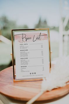 a price list sitting on top of a wooden table next to a white bird feather