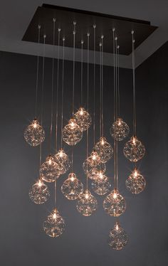 a chandelier made out of glass balls hanging from the ceiling in a room