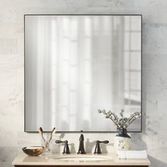 a bathroom sink with a mirror above it and two faucets on the counter