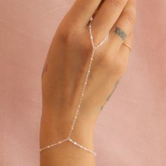 Our hand chains are a stylish piece of jewelry that connects a bracelet on your wrist to one of your fingers with delicate chains. This one is decorated with little beads, adding a unique and elegant touch. …………………………………. Details: Chain finishes 14k Gold Filled or Sterling Silver Waterproof and can be worn everyday Average bracelet size is 6.5" - 7" About Your Jewelry If you are not wearing your jewelry it is best to store it in a cool, dry place such as your gift box that is included in your or Delicate Chain Bracelet With Extender, Silver Minimalist Bracelets For Parties, Adjustable Delicate Body Chain, Dainty Adjustable Bracelet Body Jewelry, Dainty Adjustable Body Jewelry Bracelet, Minimalist Beaded Chain Bracelet, Adjustable Rose Gold Satellite Chain Bracelet, Minimalist Delicate Chain Body Chain For Gifts, Adjustable Silver Chain Ring For Parties