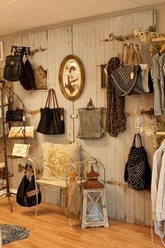 a room filled with lots of purses and handbags hanging on the wall next to each other