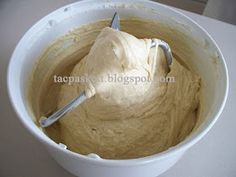 a white bowl filled with batter sitting on top of a counter next to a knife