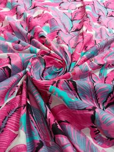 a pink and blue fabric with black leaves on the bottom, as if it were an abstract painting