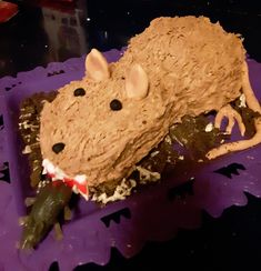 a cake shaped like a mouse on top of purple doily