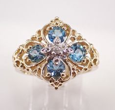 Vintage Yellow Gold Blue Topaz and Diamond ring. This ring is set with four Round Blue Topaz and one Round Brilliant Diamond.  The Blue Topaz combine to a total weight of 3/4 carat. The diamond is H color, I clarity and weighs .02 carat.  This ring is 10k Yellow Gold, weighs 5.8 grams and is a finger size 7, can be resized (please inquire about sizing with the finger size you need). The ring will be accompanied by an appraisal by a GIA Certified Diamond Grader with the retail replacement value o Topaz And Diamond Ring, Diamond Ring Unique, Vintage Art Deco Rings, Unique Diamond Rings, Deco Ring, Art Deco Ring, Ring Unique, Fine Jewelry Gift, Gia Certified Diamonds