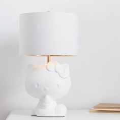 a white hello kitty lamp sitting on top of a table