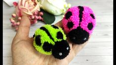 two small crocheted ladybugs sitting on top of each other in someone's hand