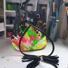 Super fun bright mini bucket bag perfect for summer, features an extra-long adjustable strap and a strong closure for safety. This bag has been hand-painted in a unique neon colour palette reminiscent of zest citrus fruits and bright pink of a dragon fruit this bag is destined to brighten your day and warm your soul   DIMESIONS  length 18cm base width 11cm  height  19cm strap length 135cm  strap adjustable or removable   adjustable but not removable opening max width  17cm  All bags are carefully sourced with a keen eye for quality and originality to ensure these items will only ever be one-of-a-kind pieces of wearable art. As our items are preloved some signs of a previous life may be visible.  All major wear and tear will be noted in the listing and additional photographs can be sent upo Trendy Summer School Bucket Bag, Trendy Yellow Bucket Bag, Trendy Multicolor Bucket Bag, Multicolor Bucket Bag For Spring, Multicolor Spring Bucket Bag, School Bucket Bag With Adjustable Strap, Multicolor Bucket Shoulder Bag For School, Summer Crossbody Bucket Bag For School, Summer School Crossbody Bucket Bag