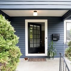 a blue house with a black door and white trim