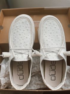 a pair of white shoes sitting on top of a box