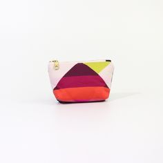 Introducing the Geometric Poofy Coin Pouch: a delightful blend of charm and versatility. This unique pouch combines a playful pink geometric pattern on one side with durable navy dry oilskin on the other, offering a stylish contrast that stands out. Measuring approximately 3.5" x 5" with a poofy, 1" gusseted design, this pouch not only holds your coins and small essentials but also stands on its own for easy access. The brass-colored metal zipper ensures secure closure, while adding a touch of vintage elegance to its modern design. Whether slipped into a purse or carried solo, the Geometric Poofy Coin Pouch is perfect for adding a pop of color and personality to your everyday carry. It's an ideal accessory for those who appreciate practicality without compromising on style. Modern Rectangular Coin Purse With Removable Pouch, Modern Coin Purse With Removable Pouch, Modern Compact Coin Purse For Personal Use, Modern Compact Wallets With Zipper Pouch, Modern Compact Coin Purse, Compact Modern Coin Purse, Modern Compact Everyday Pouch, Modern Zipper Coin Purse For Personal Use, Modern Coin Purse With Zipper Pouch For Personal Use