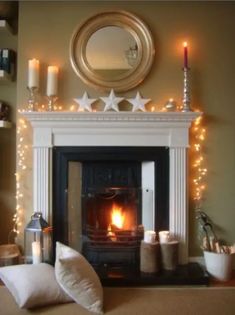 a living room with a fire place and christmas lights on the mantle, along with other decorations