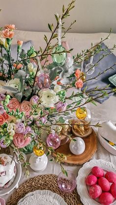 an arrangement of flowers and plates on a table