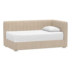 a bed with a white pillow on top of it and a light colored headboard