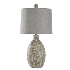 a table lamp with a gray shade on it and a white base, sitting next to a