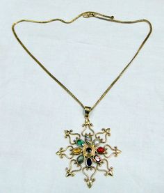 18 k solid gold, and nine different gemstones navratna pendant with chain necklace. total weight-17.200 grams, size of pendant-5.5/5 cm, length of chain-16 inches ( we can adjust to any length), name of all gems are as follows-center one is ruby than red coral, night garnet, blue sapphire, cats eye, yellow sapphire, emerald, diamond, and pearl. Navratna Pendant, Navratna Necklace, Gemstones Pendant, All Gems, Pendant With Chain, Cats Eye, Birthstone Pendant, 925 Silver Earrings, Gemstone Necklace Pendant