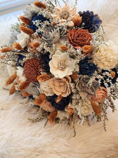 the bridal bouquet is made up of various flowers and foliage, along with feathers