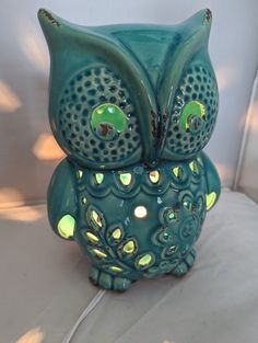 an owl figurine sitting on top of a white couch next to a lamp