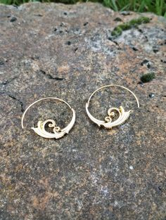 A pair of geometric earrings made of metal alloy. Elegant Spiral Metal Earrings, Unique Small Hoop Metal Earrings, Modern Swirl Earrings For Gift, Swirl Earrings For Pierced Ears, Gold Spiral Brass Hoop Earrings, Metal Spiral Earrings With Ear Wire, Spiral Metal Earrings With Ear Wire, Spiral Gold Hoop Earrings In Brass, Gold Swirl Metal Earrings