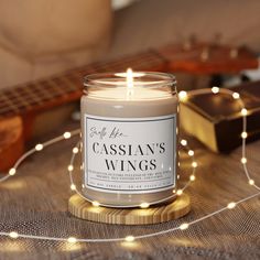 a candle sitting on top of a table next to a string of lights and a guitar