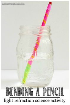 a glass jar with a pink and green straw sticking out of it's side