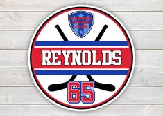 a round sticker with the words reynoldss and crossed hockey sticks