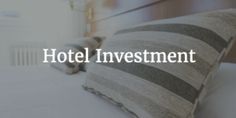 the hotel investment logo is shown above a bed with pillows and blankets on top of it