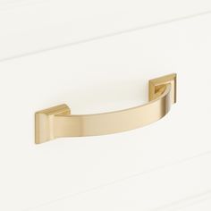 a close up of a door handle on a white cabinet