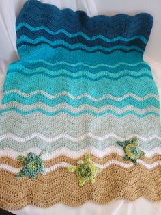 a crocheted blanket with two sea turtles on the bottom and waves in the middle