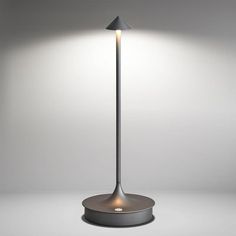 a lamp that is sitting on top of a table next to a white wall and floor