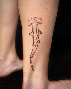 a woman's foot with a tattoo on it that has a hammer in the shape of a shark