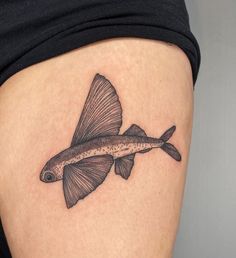 a small fish tattoo on the thigh