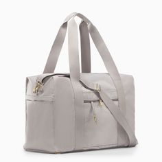 a large gray bag with two zippers on the front and one side, sitting in front of a white background