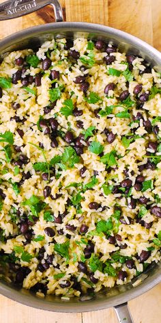 a pot filled with rice and beans on top of a wooden table