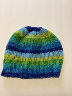 This soft, hand-knit hat/beanie will comfortably fit most adults and teens. It's made using a fun, self-striping and soft yarn that will be warm and comfortable. Hand-knit (NOT loomed or machine-knit) using a high-quality, super-soft striping yarn. You'll reach for this hat again and again on your way out the door, so the easy-care yarn means you can machine wash and dry your hat whenever you want. Striped Winter Hats One Size Fits Most, Striped Beanie Hat, One Size Fits Most, Striped Beanie Hat One Size, Winter Striped Hats One Size Fits Most, Casual Acrylic Yarn Beanie Hat, Casual Acrylic Yarn Cap, Casual Striped Cap, Adjustable Striped Winter Hat, Comfortable Knitted Cap Hat