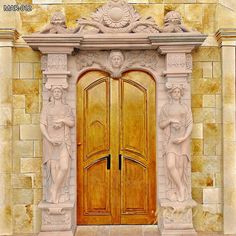 a large wooden door with statues on the outside and in between it's sides