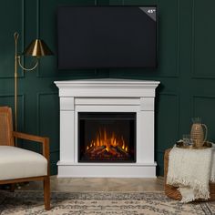 a living room with a fireplace, chair and flat screen tv on the green wall