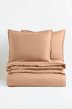 the linen sheets and pillowcases are folded up on top of each other,