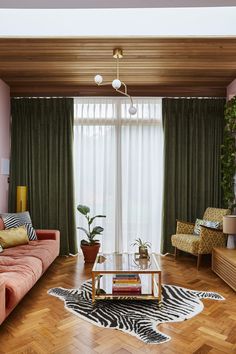 a living room with zebra print rug and green curtains