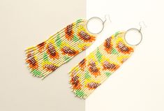 These boho style beaded earrings are made in Latvia  of high-quality Czech beads and strong synthetic thread.    Hypoallergenic Earring Hooks. Earrings are 17 cm ( 6.7 inches)  length with hooks and 5.5 cm ( 2.1 inches) width. Colors: yellow,orange,brown,green. 100% handmade. Don't forget to check out my other jewelry in the store. Maybe you will find exactly what you are looking for. https://www.etsy.com/shop/SandasHandmades The photo may not convey true colors. This may depend on the settings Artisan Multicolor Round Beaded Earrings, Bohemian Multicolor Round Beaded Earrings, Bohemian Multicolor Beaded Round Earrings, Multicolor Large Beaded Round Earrings, Multicolor Bohemian Hand-strung Beaded Earrings, Quartz Hoop Earrings, Funny Earrings, Statement Hoop Earrings, Beaded Earrings Native