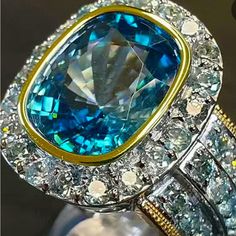 Blue Topaz Statement Two-Tone With Three Side Rows And Hallow Zircon On Cigar Band Cocktail Ring All My Rings I Am Able To Sell At A Affordable Price Because I Believe Everyone Deserves A Little Bling This Is An Exceptional Piece Light Blue Aquamarine Jewelry With Diamond Accents, Blue Aquamarine Fine Jewelry, Dazzling Blue Topaz Ring With Halo Setting, Dazzling Oval Blue Jewelry, Dazzling Blue Aquamarine Jewelry, Silver Aquamarine Jewelry With Halo Setting, Blue Topaz Jewelry With Accent Stones, Dazzling Blue Jewelry With Gemstone Accents, Light Blue Round Sapphire Jewelry