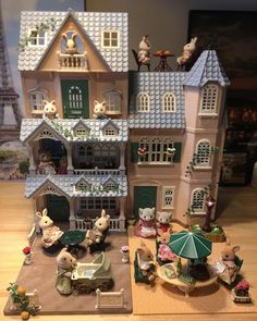 a toy house with animals and people around it