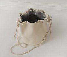 Vegan white leather drawstring bucket bag with cotton rope Casual Cream Bucket Bag Tote, Cream Bucket Bag With Adjustable Strap For Shopping, Cream Casual Bucket Bag For Shopping, Casual Cream Bucket Bag For Daily Use, Beige Bucket Bag With Adjustable Strap, Cream Leather Bucket Bag With Braided Handles, Cream Bucket Bag For Everyday Use, Cream Bucket Bag For Everyday Spring Use, Casual Cream Bucket Bag For Everyday