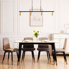 a dining room table with four chairs and a vase on the table in front of it