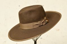 "1940s Wide Brim Western Hat Brown Beaver Fur Felt w/ Wide Rayon Band & Artisan Hat Pin  Chocolate brown beaver wool with wide rayon band & trim. Hat had been stretched to fit a larger head, rayon band had torn away from itself. Pin's had been placed to cover the gap perfectly (: A couple small holes as shown (could have been a part of the original boiling process?) This had is GORGEOUS. Measures 22.5\" around inside height: 4.5\" brim: 4\"" Vintage Fur Felt Fedora For Fall, Vintage Fedora With Curved Brim For Fall, Vintage Wide Brim Fur Felt Fedora, Vintage Brimmed Fedora For Fall, Vintage Fitted Felt Hat For Ranch, Vintage Adjustable Fur Felt Hat, Vintage Flat Bill Felt Hat For Winter, Adjustable Vintage Fur Felt Hat, Vintage Flat Brim Felt Hat For Fall