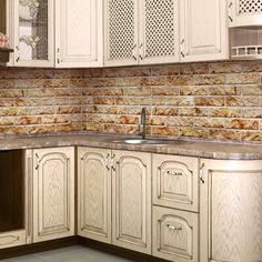 a kitchen with white cabinets and marble counter tops